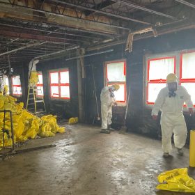 a photo of two contractors cleaning up a space at the grace hospital.